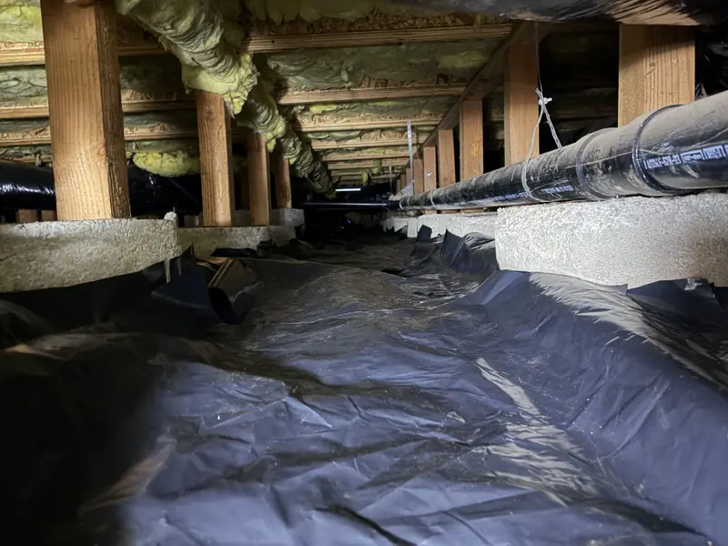 Posts and beam supporting floor framing over a clean crawl space