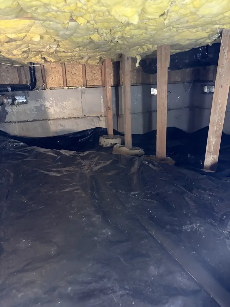 Row of wood support posts under floor insulation